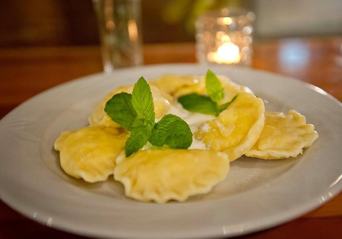 Plate of handmade Polish pierogi with fresh herbs