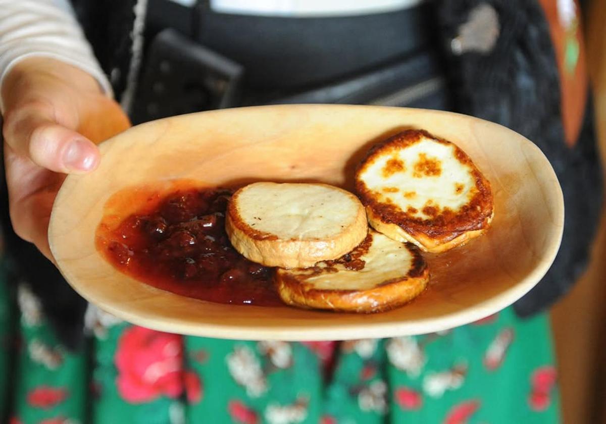 Oscypek cheese with cranberry sauce served on a wooden plate