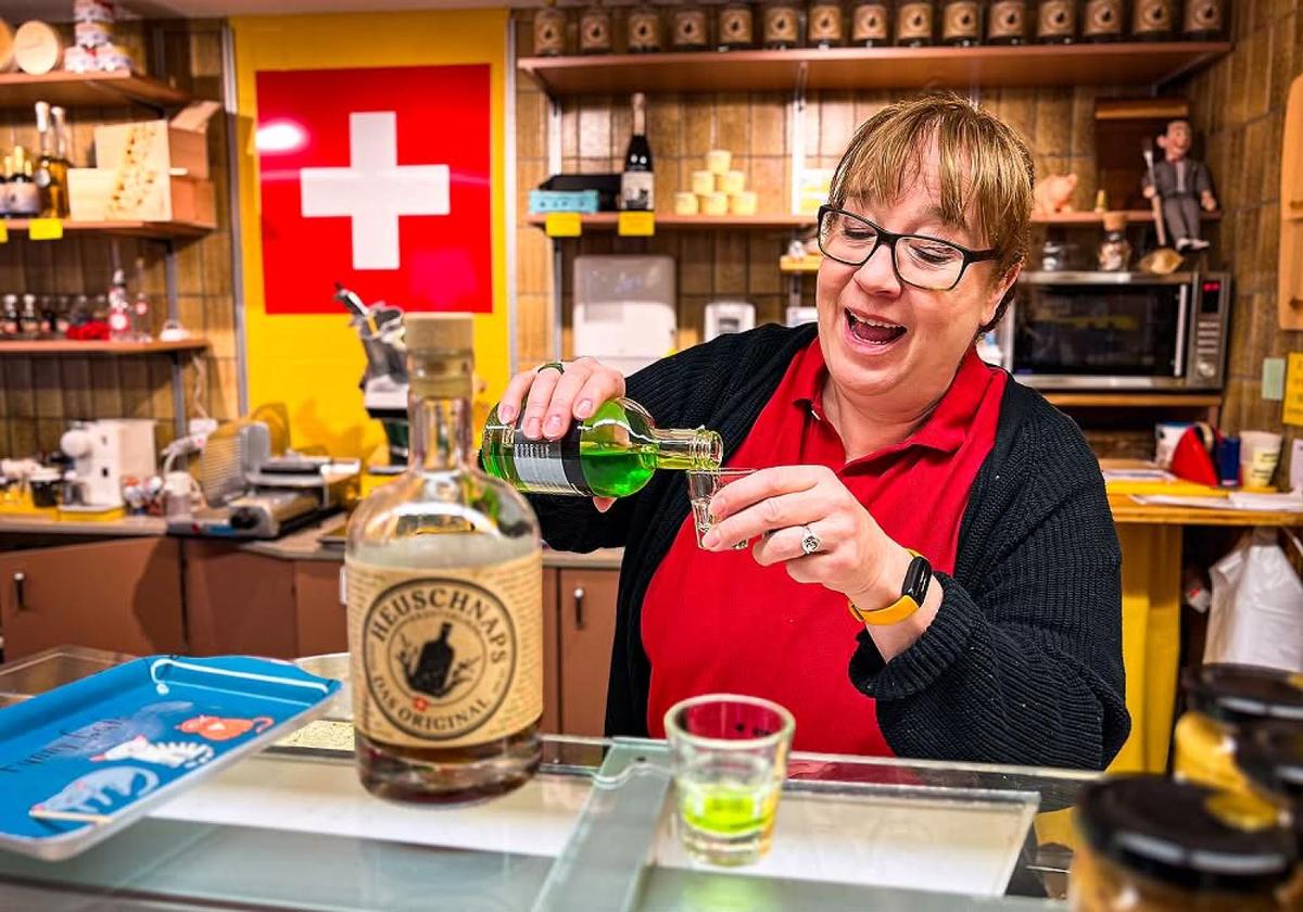 Local vendor pouring a traditional Swiss drink at a market stall