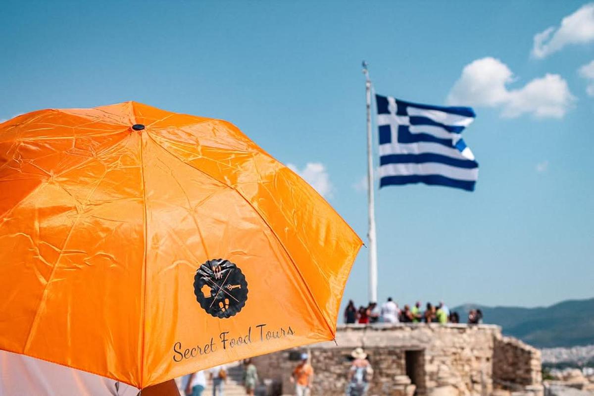 Secret Food Tours orange umbrella with Greek flag in the background