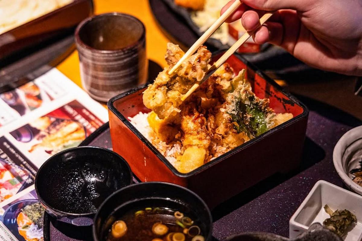 Close-up of tempura dish being picked up with chopsticks at a restaurant