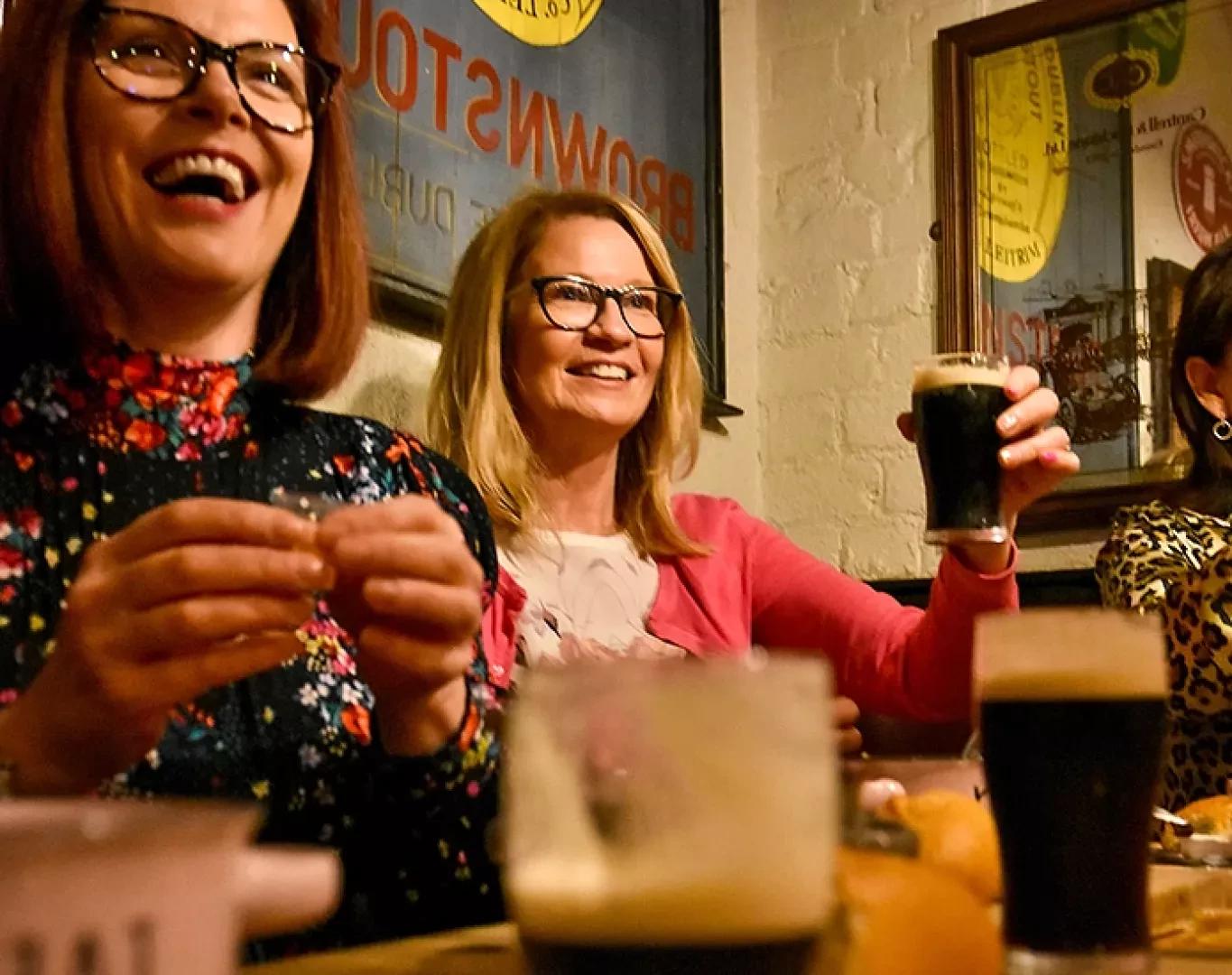 Guests enjoying local beer tasting inside a cozy pub on food tour