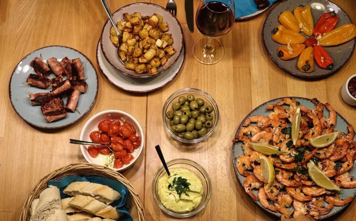 Traditional Spanish tapas dishes on a wooden table in Madrid, Spain.