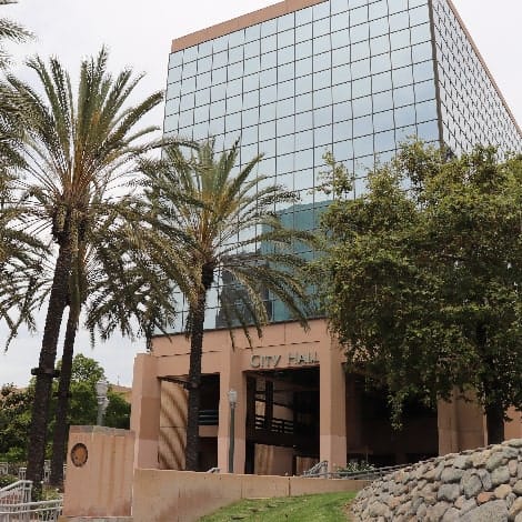 View of Anaheim City Hall from the street with trees and rock structure