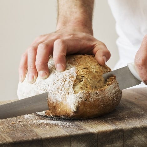 close up of a baker slicing a freshly baked