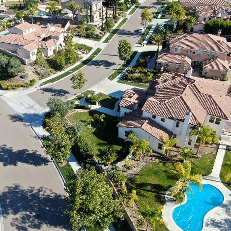 Aerial view of neighborhood with residential modern subdivision luxury houses and small road during sunny day in Chula Vista