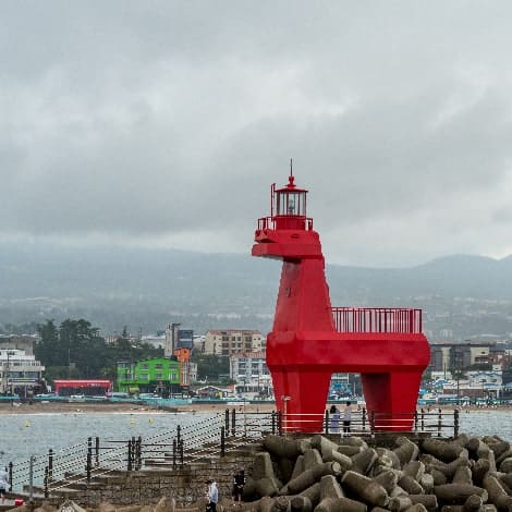 Tourists are under a red lighthouse of horse shape