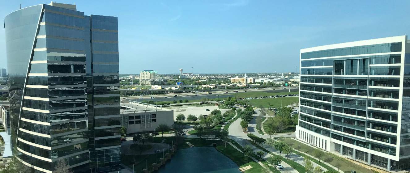 TX shot from office building with water tower and highway in the distance.